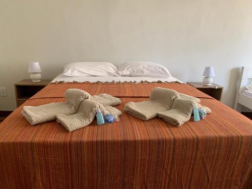 um grupo de três toalhas numa cama em Casa do Sol Fortaleza em Fortaleza