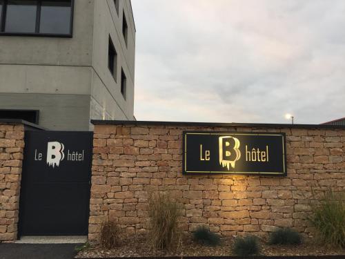 a building with a sign that reads le hotel at Le B Complexe Hôtel in Lozanne