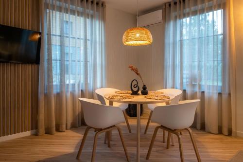 a dining room with a table and white chairs at SEA SALT home - Karkle - by Hello Sea homes in Karklė