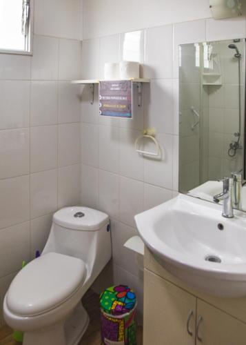 a white bathroom with a toilet and a sink at Loft Tongoy 1 frente al mar in Coquimbo