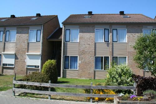 a house with a fence in front of it at Schorrebloem 10 in Nieuwvliet