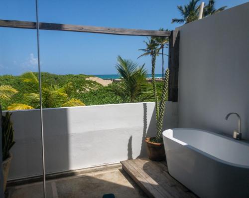 a bathroom with a tub and a view of the ocean at Residencial Mañanero in Cabarete