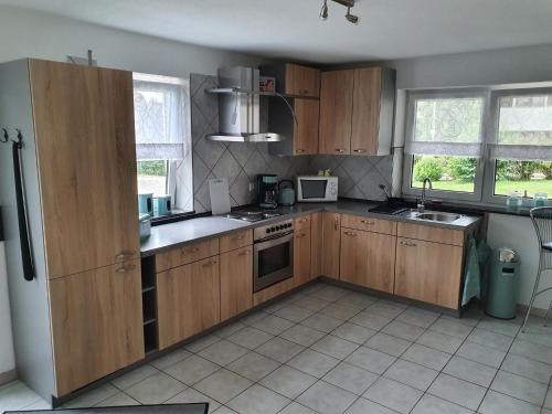 a kitchen with wooden cabinets and a stove top oven at FEWO Kug in Mengen