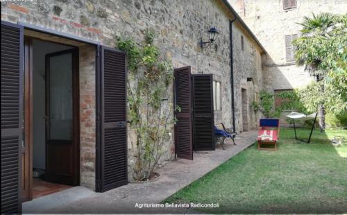 a brick building with open doors and a yard at Agriturismo Bellavista in Radicondoli