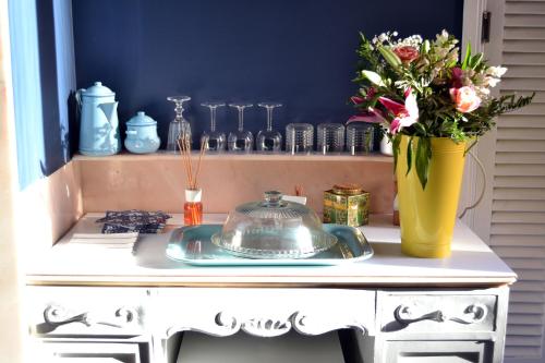 une table avec une assiette et un vase de fleurs dans l'établissement Babbo Guest House, à Rome