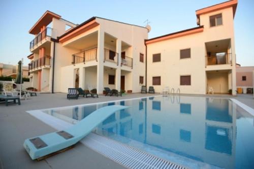a villa with a swimming pool and a house at Lina apartments in Ginosa Marina
