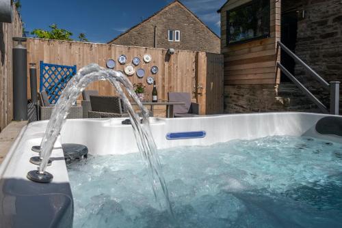 un bain à remous avec une fontaine dans l'arrière-cour dans l'établissement Naze View Barn - Cosy, with all mod cons, à Whaley Bridge