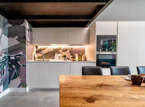 a kitchen with white cabinets and a wooden table at Studio 27 Verona in Verona
