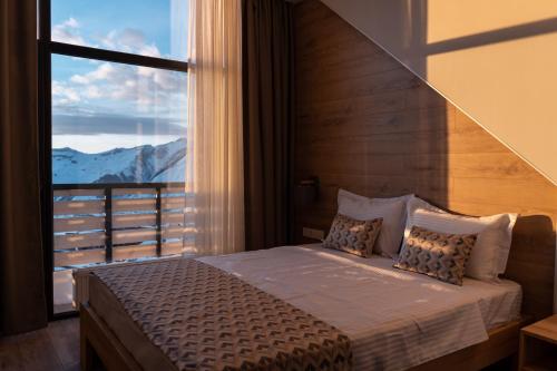 a bedroom with a bed with a large window at Gogi Ski Resort in Gudauri