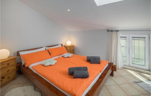 a bedroom with an orange bed with two towels on it at Gorgeous Apartment In Musalez With Kitchen in Musalez