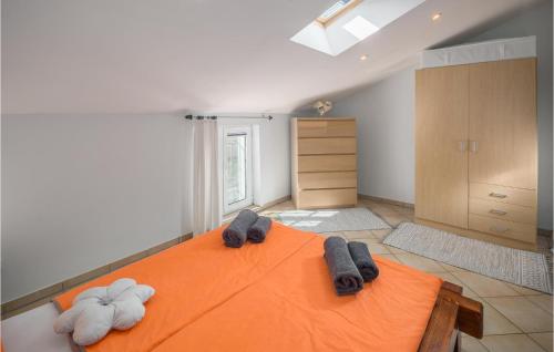 a bedroom with an orange bed with towels on it at Gorgeous Apartment In Musalez With Kitchen in Musalez