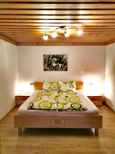 a bedroom with a large bed with yellow and white sheets at Ferienwohnungen Birkleiten in Bramberg am Wildkogel