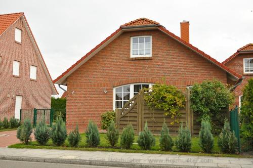 Casa de ladrillo rojo con puerta de madera en Ferienhaus Villa Hildabert, en Norden