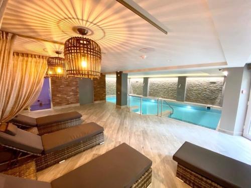 a living room with a chandelier and a swimming pool at Bushtown Hotel & Spa in Coleraine