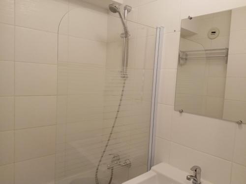 une salle de bain avec une douche, un lavabo et un miroir dans l'établissement Appartement moderne avec terrasse et parking, près des pistes, pour 6 personnes - FR-1-198-217, à Châtel