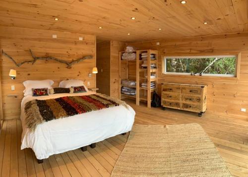 a bedroom with a bed in a wooden cabin at CASA LOICA in Chonchi