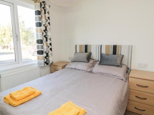 a bedroom with a bed with two towels on it at Pinecone Lodge - No 9 in Morpeth