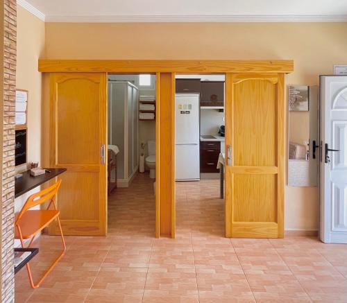 a living room with wooden doors and a kitchen at CASA ROSALÍA. APARTAMENTO CON VISTAS A LA MONTAÑA in Teror