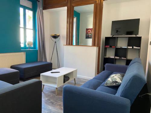 ein Wohnzimmer mit 2 blauen Sofas und einem TV in der Unterkunft Maison Cosy 10 Personnes 3 SDB proche Lille in Roubaix
