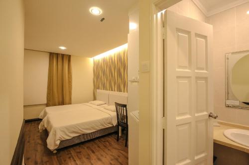 a hotel room with a bed and a sink at Hotel Ming Star in Kuala Terengganu