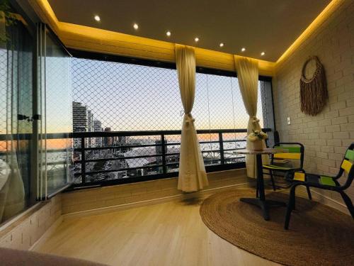 um quarto com uma varanda com uma mesa e uma vista em Flat Luxuoso Alto Padrao Frente Mar com 2 suites no Iate Plaza em Fortaleza