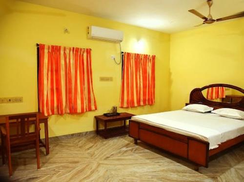 a bedroom with a bed and two windows at Smith Guest House in Puducherry
