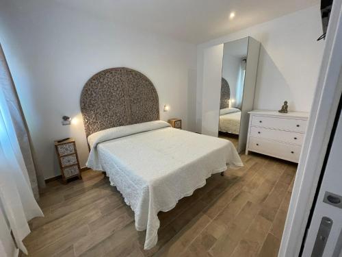 een slaapkamer met een bed, een dressoir en een spiegel bij Le Sirene Casa Vacanza in Torvaianica