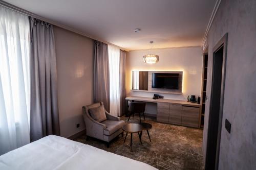 a hotel room with a bed and a chair and a desk at HOTEL EUROPA in Komárno