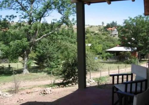 een veranda met een bank en uitzicht op een veld bij El Encuentro in Tanti