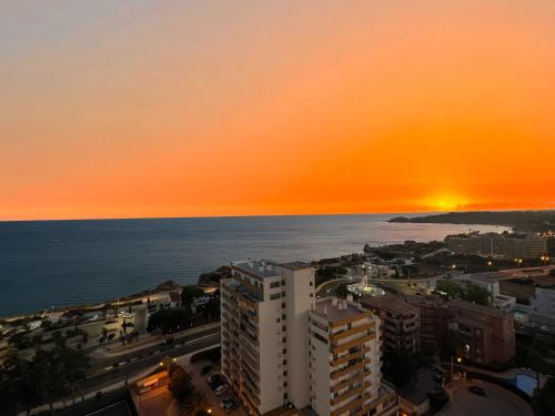 una puesta de sol sobre el océano y una ciudad en Top Ocean View Apartment - amazing sunset - modern style - pool & 200m to beach, en Portimão