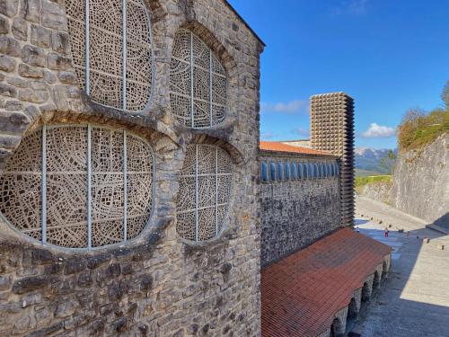 a brick wall with windows on it with a bench at Iraipe Santuario de Arantzazu Hotel in Oñate