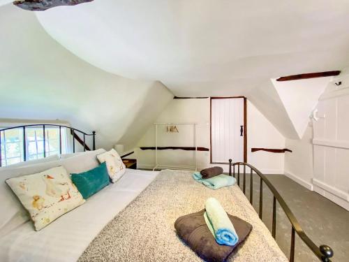 um quarto com uma grande cama branca num quarto em Mortimer Cottage em Wootton Rivers