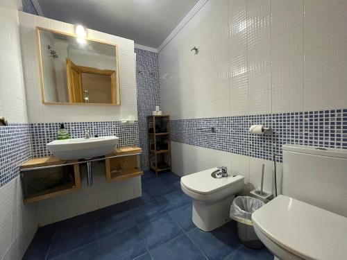 a bathroom with a sink and a toilet and a mirror at Las Nasas, Acogedor apartamento cerca de la playa in Arinaga