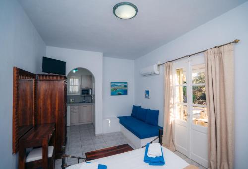 a living room with a blue couch and a window at Giannakas Studios in Platis Yialos Sifnos