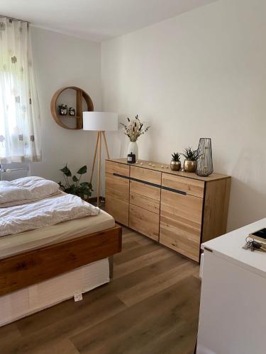 a bedroom with a bed and a dresser with a lamp at Bergkristall 304 in Hauzenberg