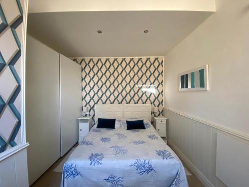 1 dormitorio con 1 cama con sábanas azules y blancas en Perla Blu, en Viareggio