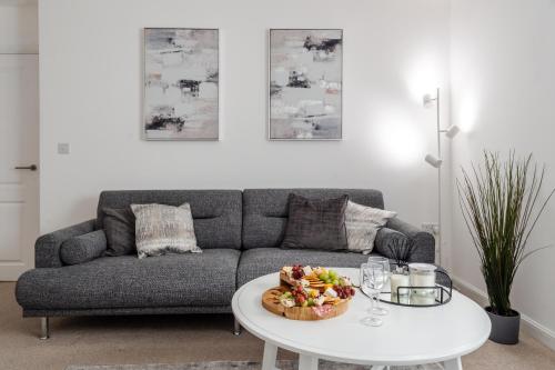 uma sala de estar com um sofá e uma mesa em Lovely Modern 2 Bed City Centre Apartment with FREE parking - Double or Twin Beds Available em Wolverhampton