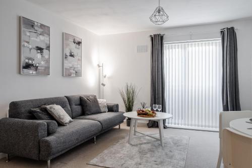 a living room with a couch and a table at Lovely Modern 2 Bed City Centre Apartment with FREE parking - Double or Twin Beds Available in Wolverhampton
