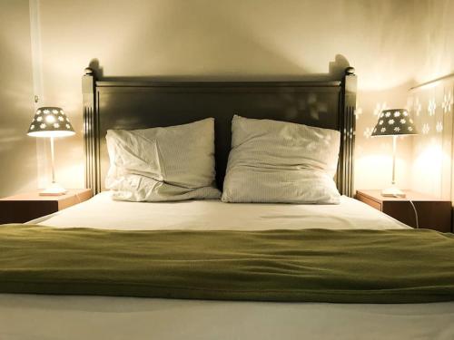 - une chambre avec un lit et deux lampes de chaque côté dans l'établissement Centre Cauterets, appartement 72m2 pr 7 personnes, à Cauterets