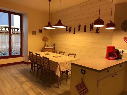 Centre Cauterets, appartement 72m2 pr 7 personnes في كوتيريه: مطبخ مع طاولة وكراسي في مطبخ