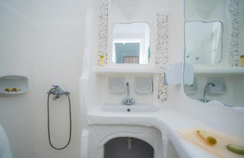 a white bathroom with a sink and a mirror at Giannakas Studios in Platis Yialos Sifnos