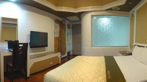 a bedroom with a bed and a large window at Hua Yue Hotel in Taoyuan