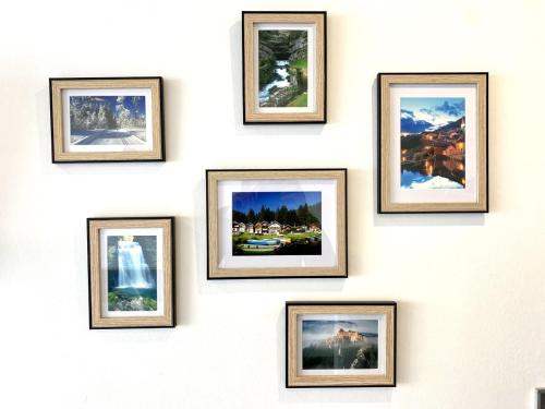 eine Wand aus gerahmten Fotos an einer Wand in der Unterkunft Le moulin vieux in Pontarlier