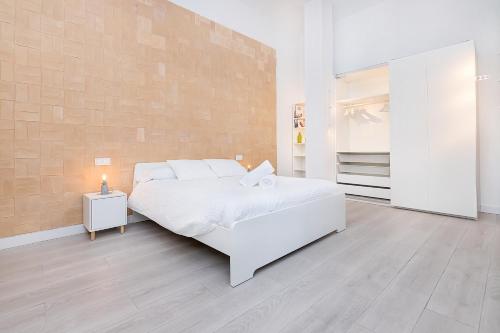 Dormitorio blanco con cama blanca y pared en Homey apt Cómpeta, en Cómpeta