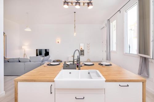 a kitchen with a sink and a living room at Homey apt Cómpeta in Cómpeta