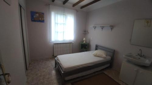 um quarto com uma cama, uma janela e um lavatório em La clairière em Pierrelongue