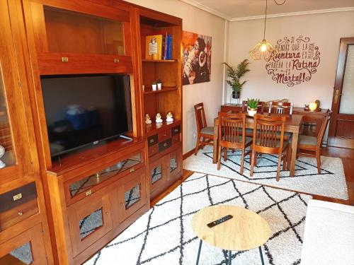 ein Wohnzimmer mit einem Esstisch und einem TV in der Unterkunft LA ERIA I, muy soleado, Wifi, garaje, 15 min a pie al centro in Oviedo