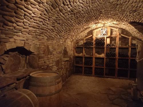 a wine cellar with a barrel and a wall of wine bottles at Dom Winiarza in Krosno