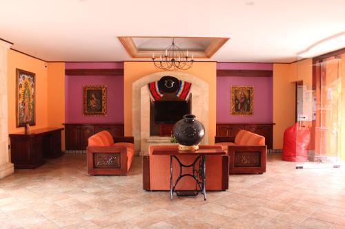 uma sala de estar com paredes cor de laranja e roxo em Santa Helena Plaza em Oaxaca de Juárez