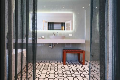 a bathroom with a sink and a table and a mirror at Hotel Alexandra in Copenhagen